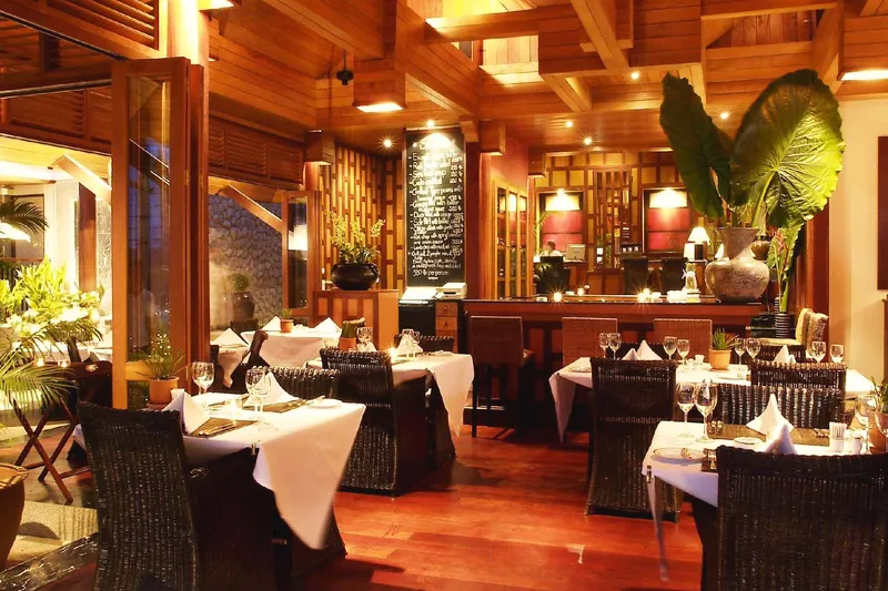 The RICE dining room: teak, white linen, candles and the bar